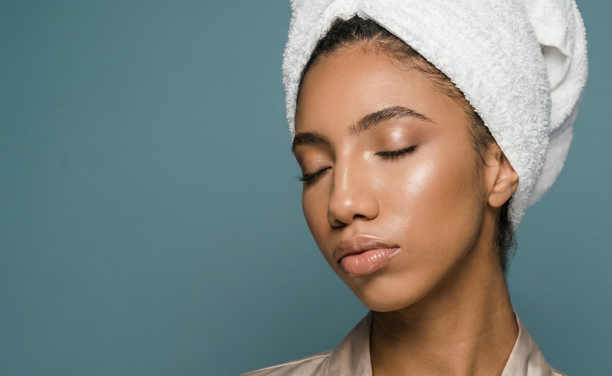Woman with a towel wrapped around her head against a blue background